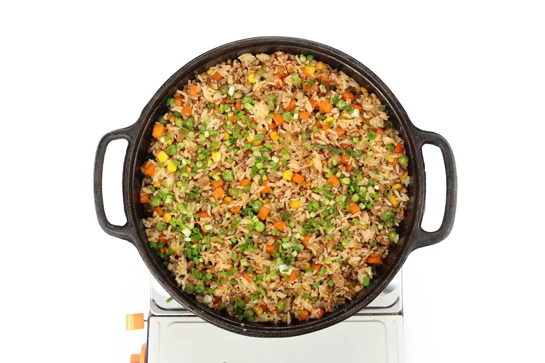 a cast iron skillet of cooked pork fried rice