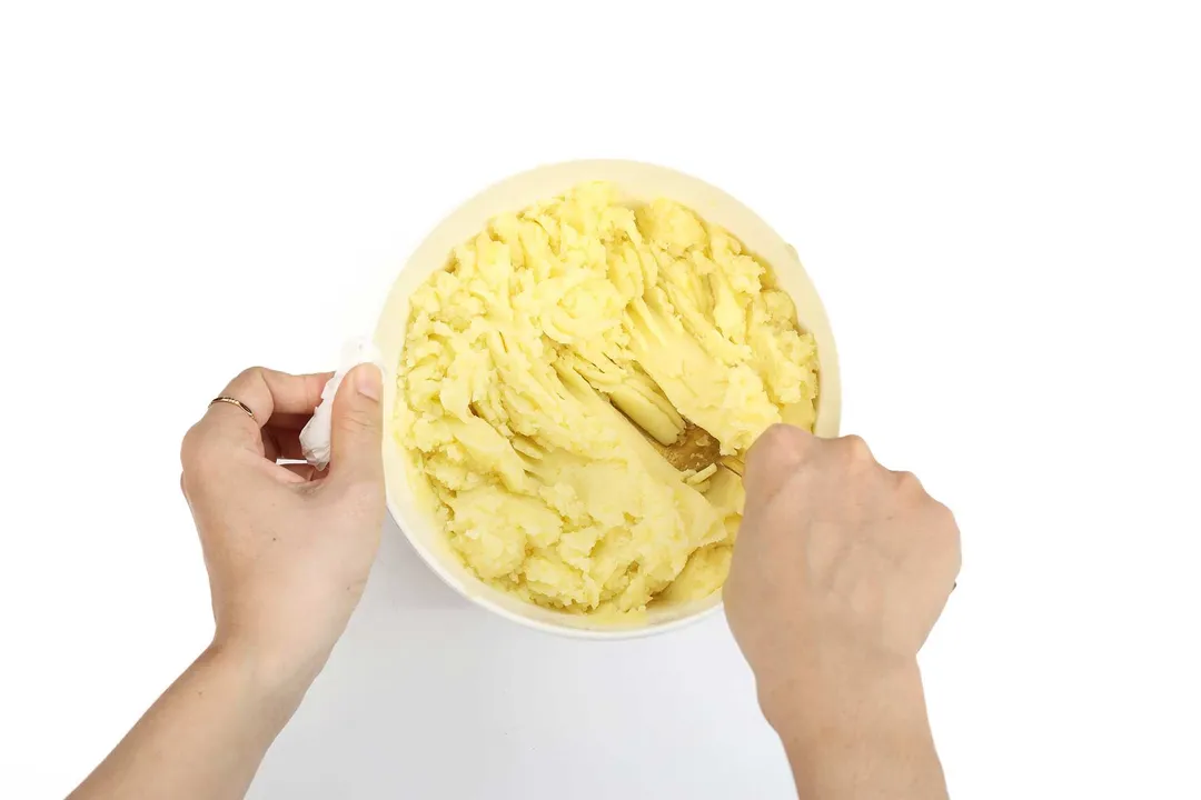 mashing potato by a fork in a bowl