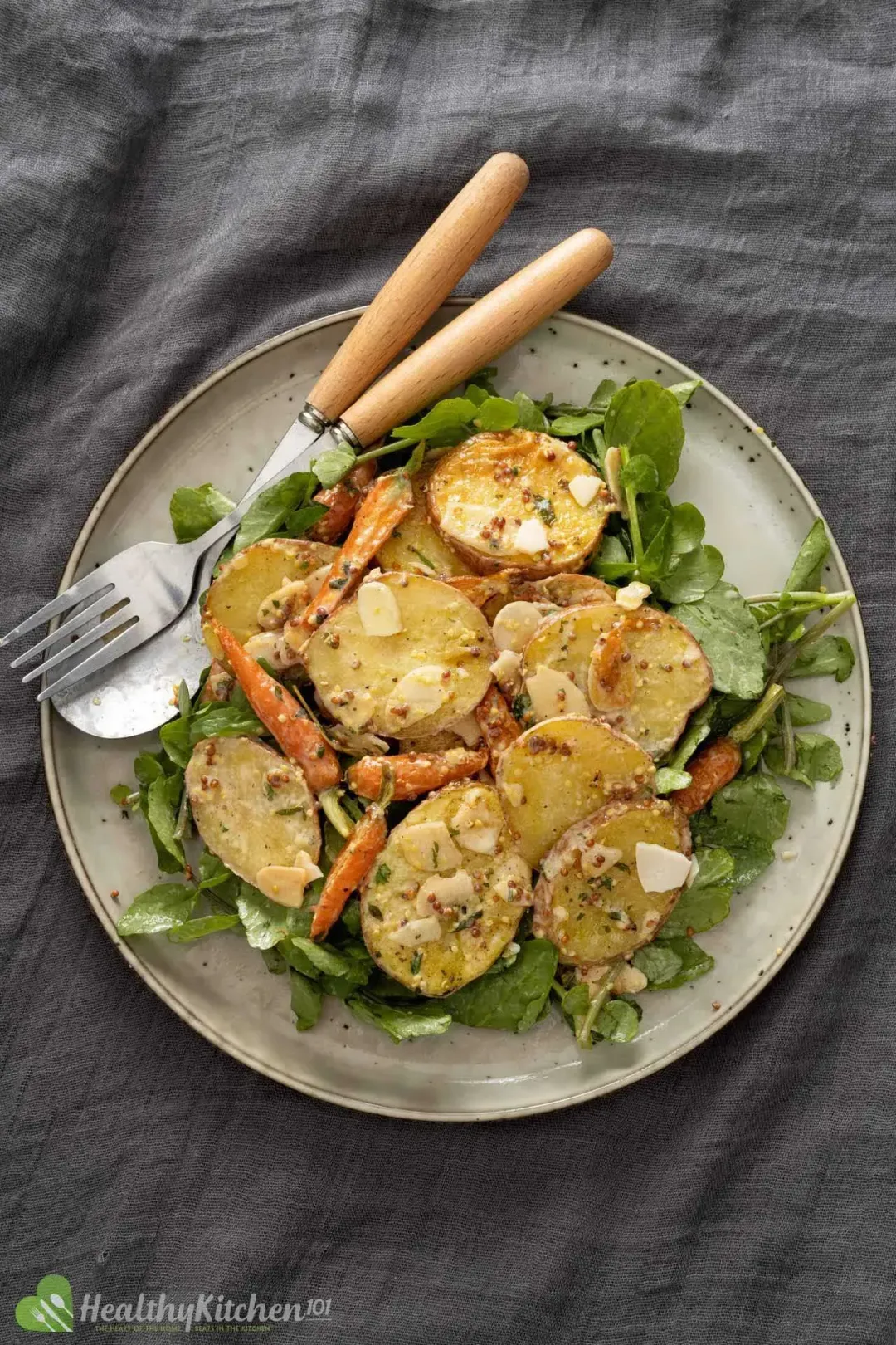 A bowl of mustard potato salad with sliced potatoes, green onions, and parsley on top.