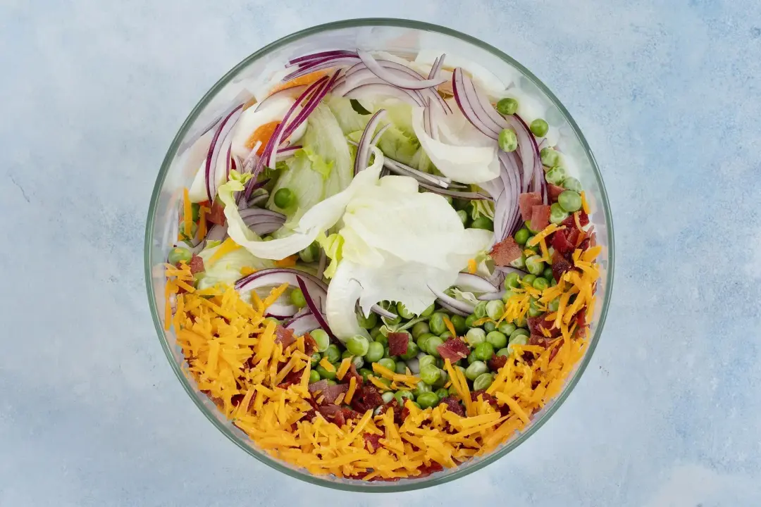 Get a large salad bowl layer in the ingredients
