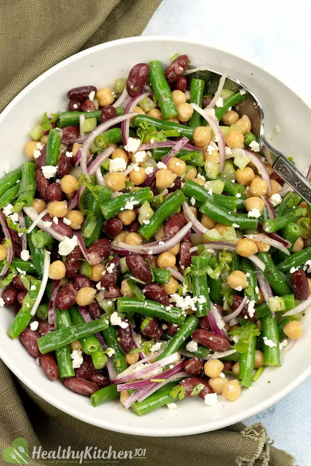 Three-bean salad on a plate with green beans, chickpeas, kidney beans, and other herbs