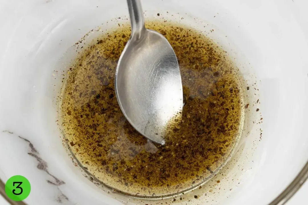 A vinaigrette dressing stirred in a glass bowl