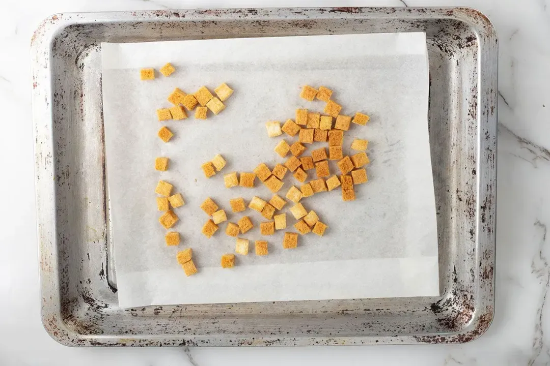 Crunchy croutons on a lined baking tray