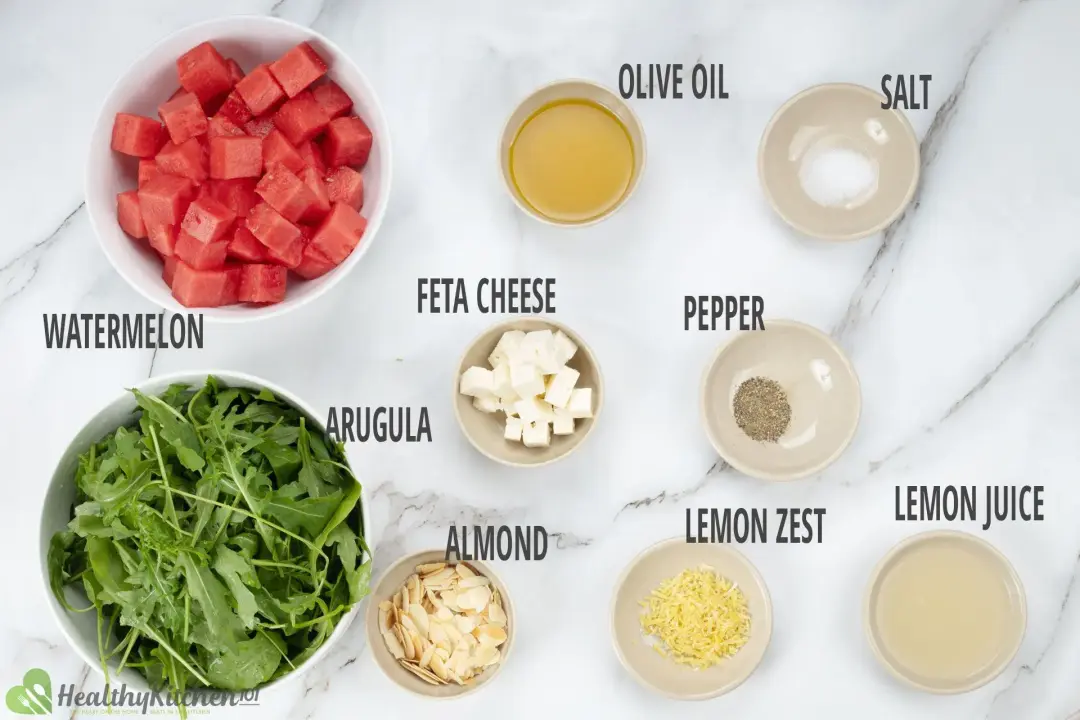 Ingredients in separate bowls: cubed watermelon, rinsed arugula, shaved almonds, cubed feta, and other ingredients
