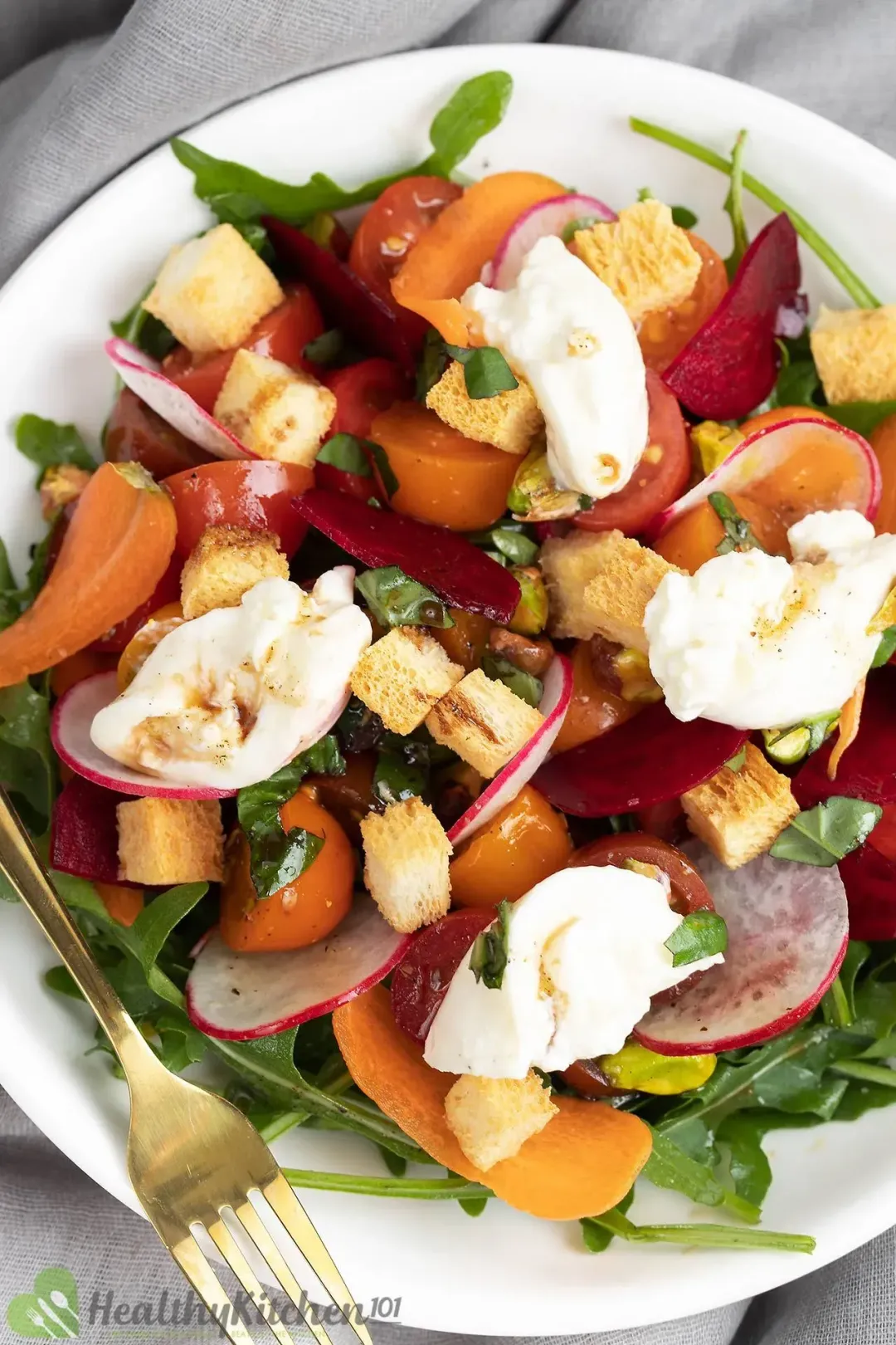 Burrata salad with tomatoes, basil, and burrata cheese slices, and croutons