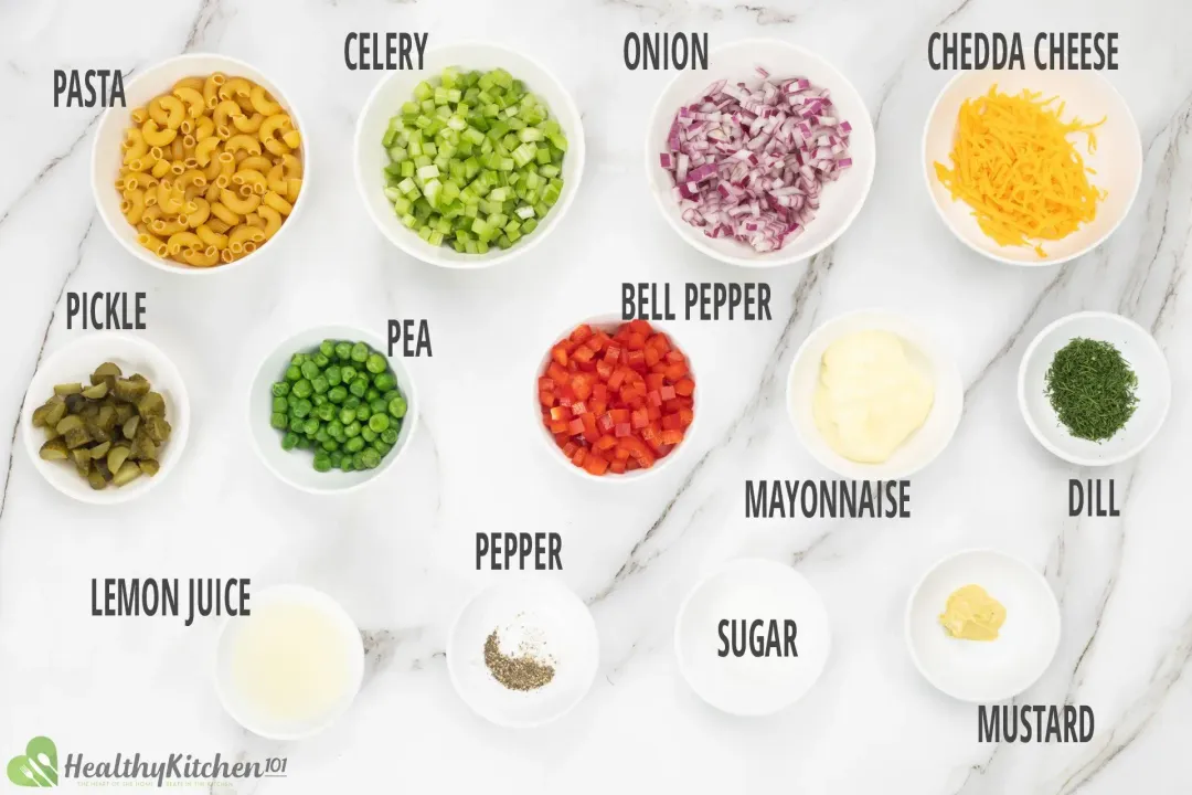 Ingredients in separate bowls: raw macaroni, celery, onion bits, cheddar shreds, peppers, peas, pickle mince, and dressing ingredients