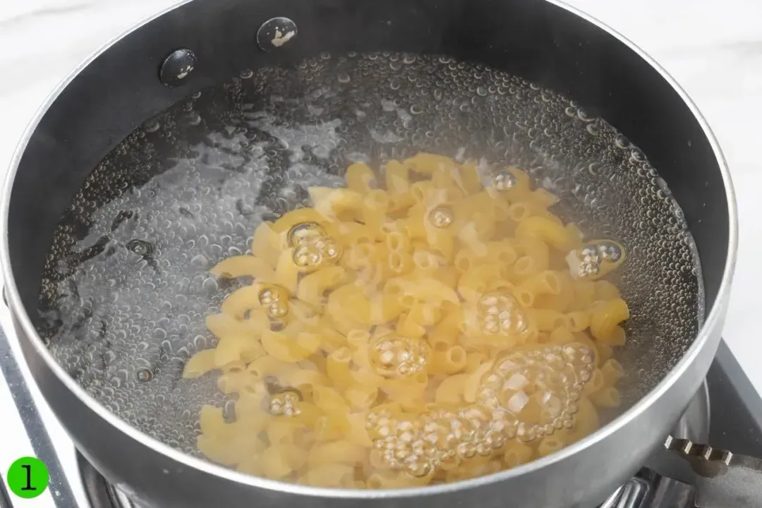A pot of cooked macaroni on a stove.