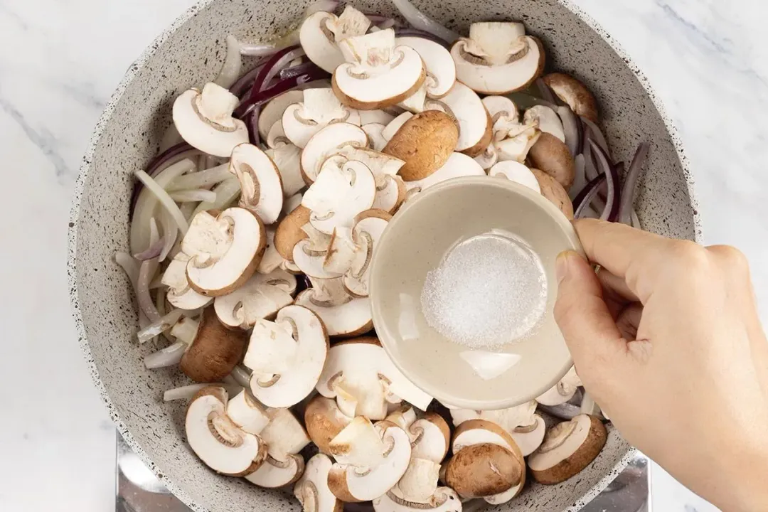 a skillet of sliced button mushrooms