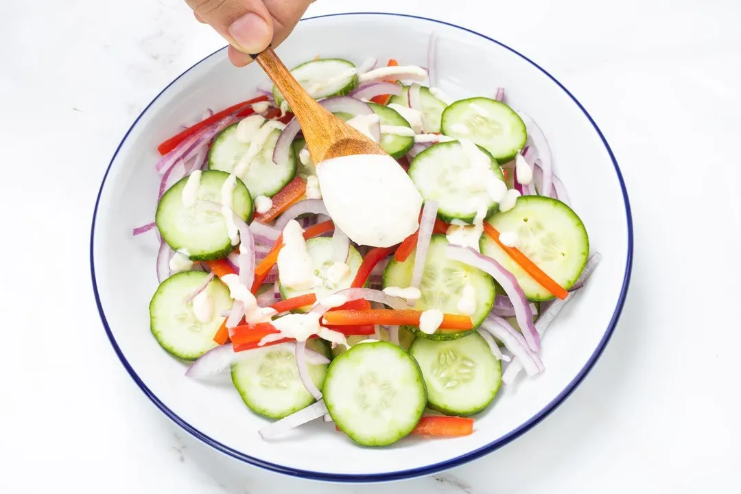 a wooden spoon on top of a salad plate