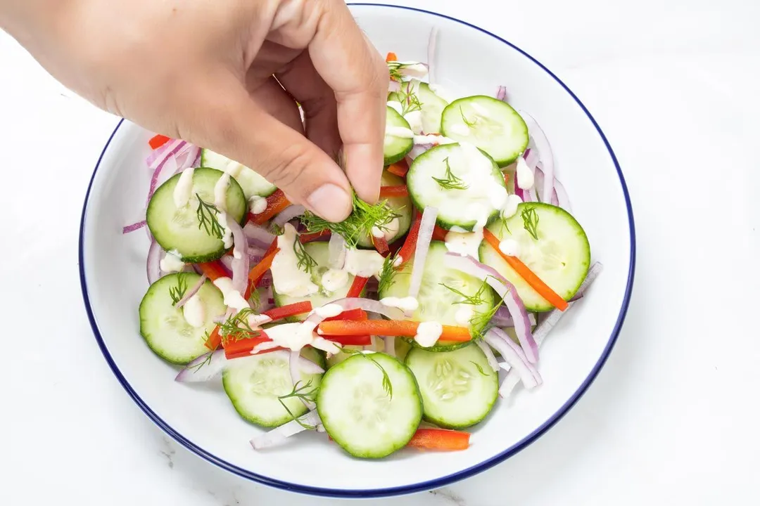 sprinkle dill on top of a salad plate