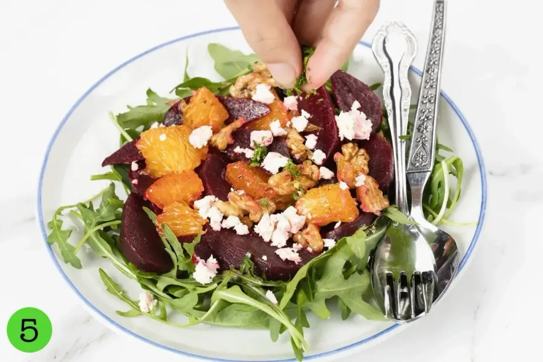 A bowl of beet and feta cheese salad with a fork on the side.