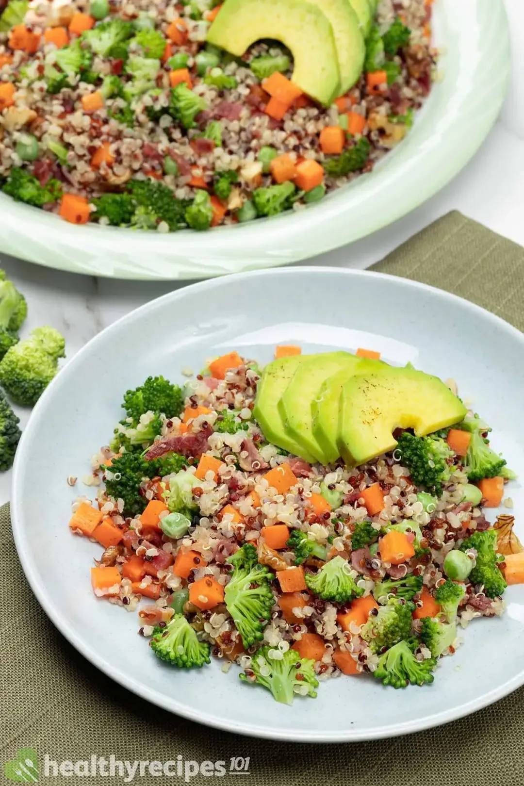 A mixture of cooked quinoa, vegetables and herbs in a bowl.