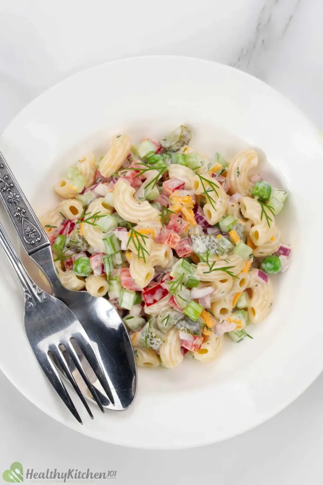 A bowl of macaroni salad with diced vegetables and dressing.
