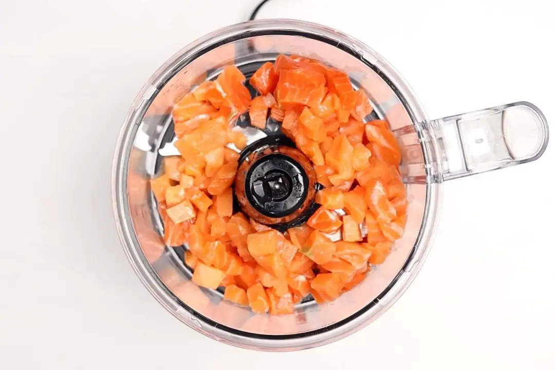 Cubes of salmon in a food processor.