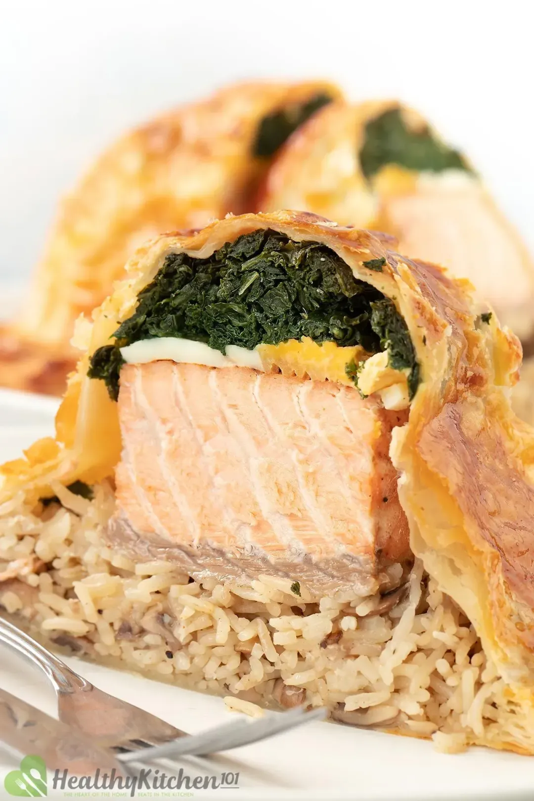 Layers of cooked kale, boiled eggs, salmon, and mushroom rice wrapped in pastry