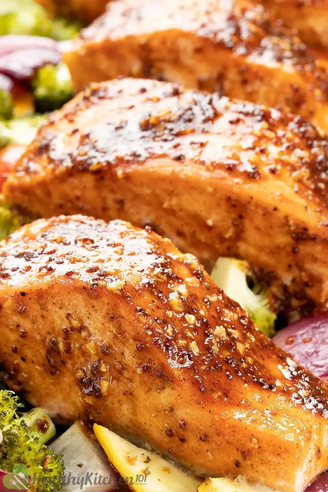 A close-up shot on pieces of cooked salmon glazed with a glossy brown honey sauce