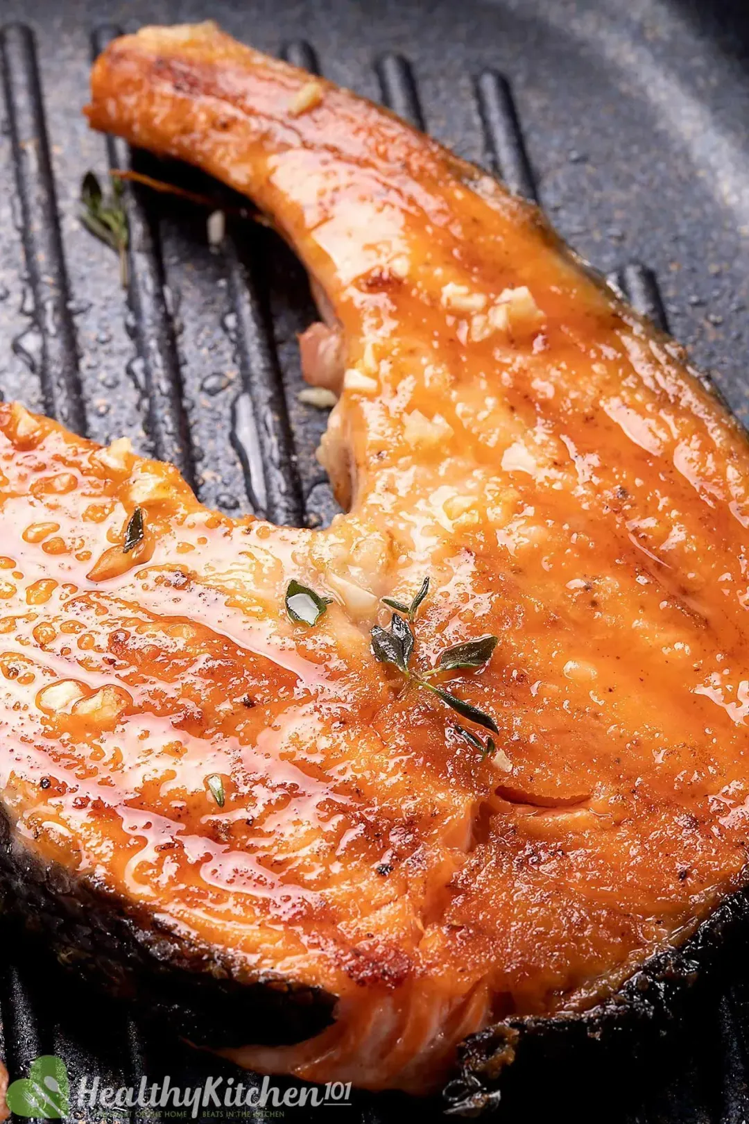 A salmon steak golden and glistening on a grillpan