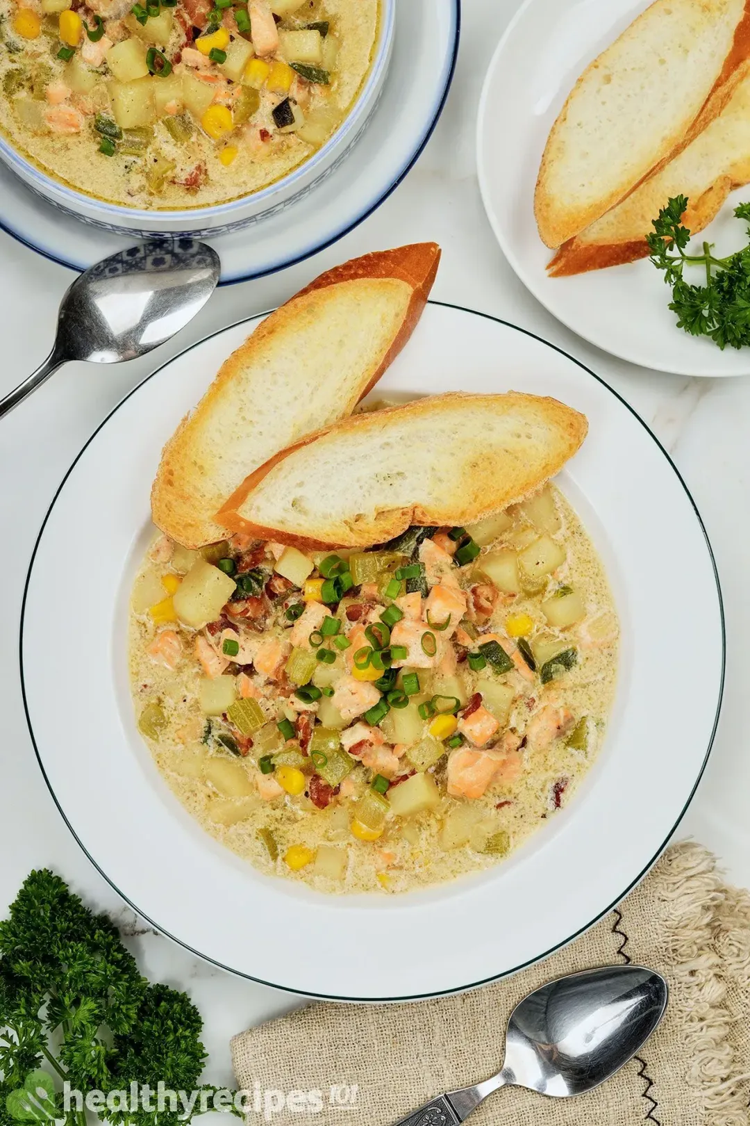 A shallow platter of salmon chowder topped with two slices of air-fried baguette