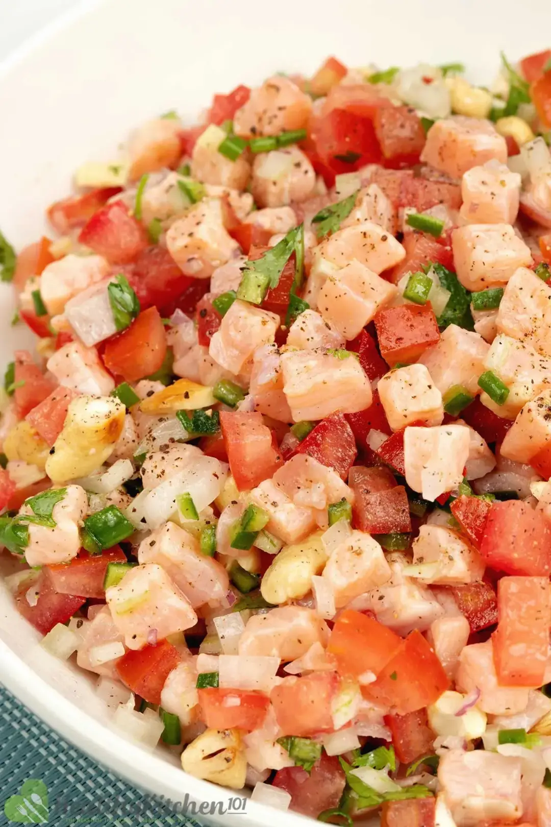 A mixture of cubed salmon, tomato, and chopped cilantro
