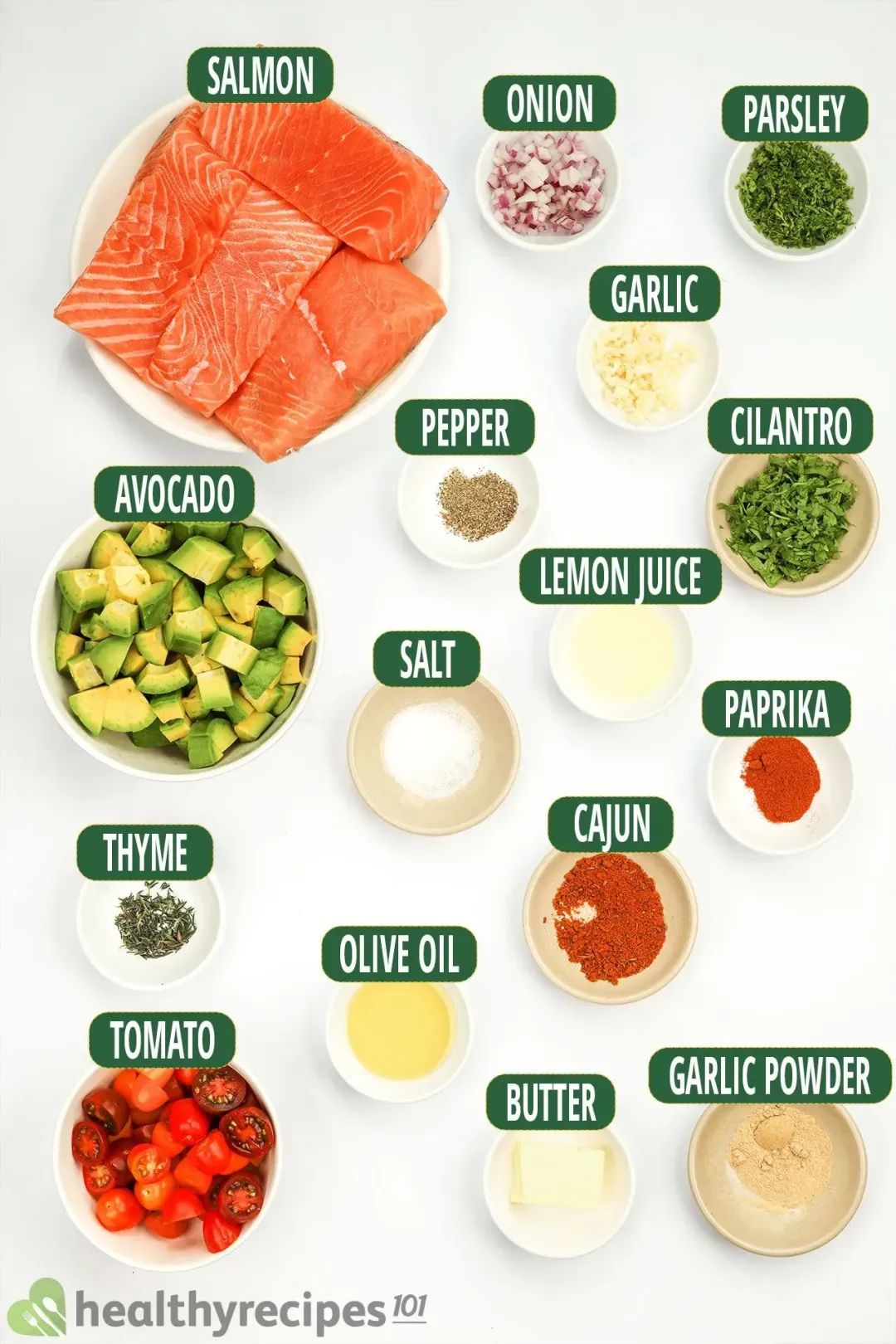 Ingredients for salmon avocado: salmon fillets, cubed avocados, halved cherry tomatoes, and other seasonings