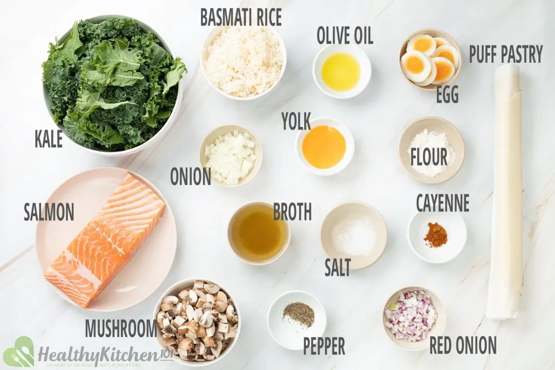 Ingredients in separate bowls and plates: salmon filet, fresh kale, rice, quartered mushrooms, boiled eggs, and seasonings 