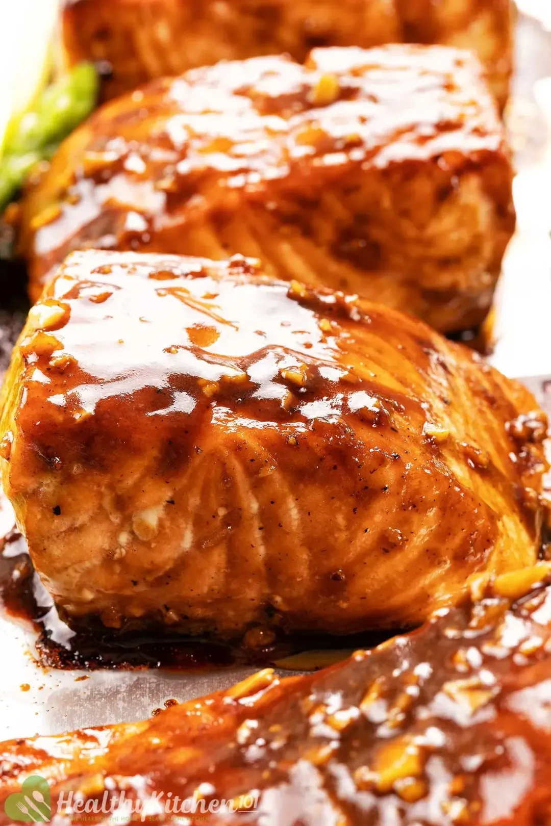 A close view of baked salmon filets coated in a generous amount of teriyaki sauce.