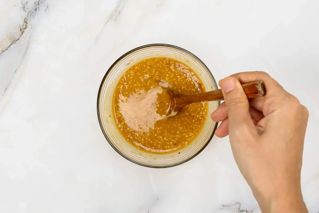 Mixing the sesame dressing in a small bowl