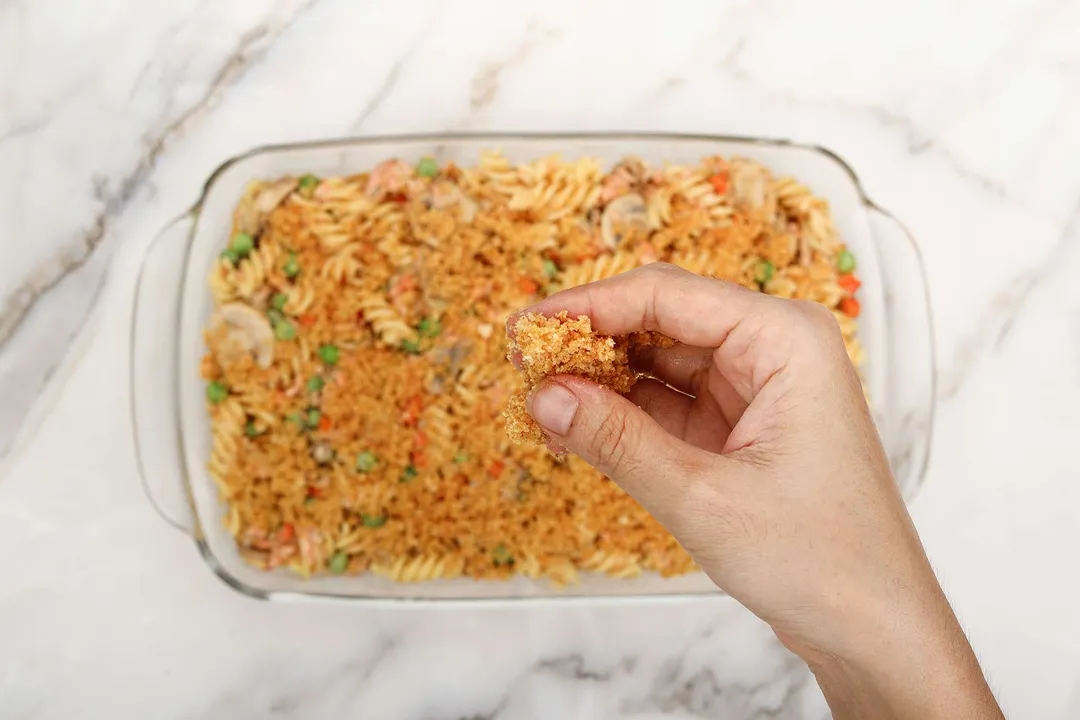 sprinkle panko breadcrumb on top of a baking dish of pasta