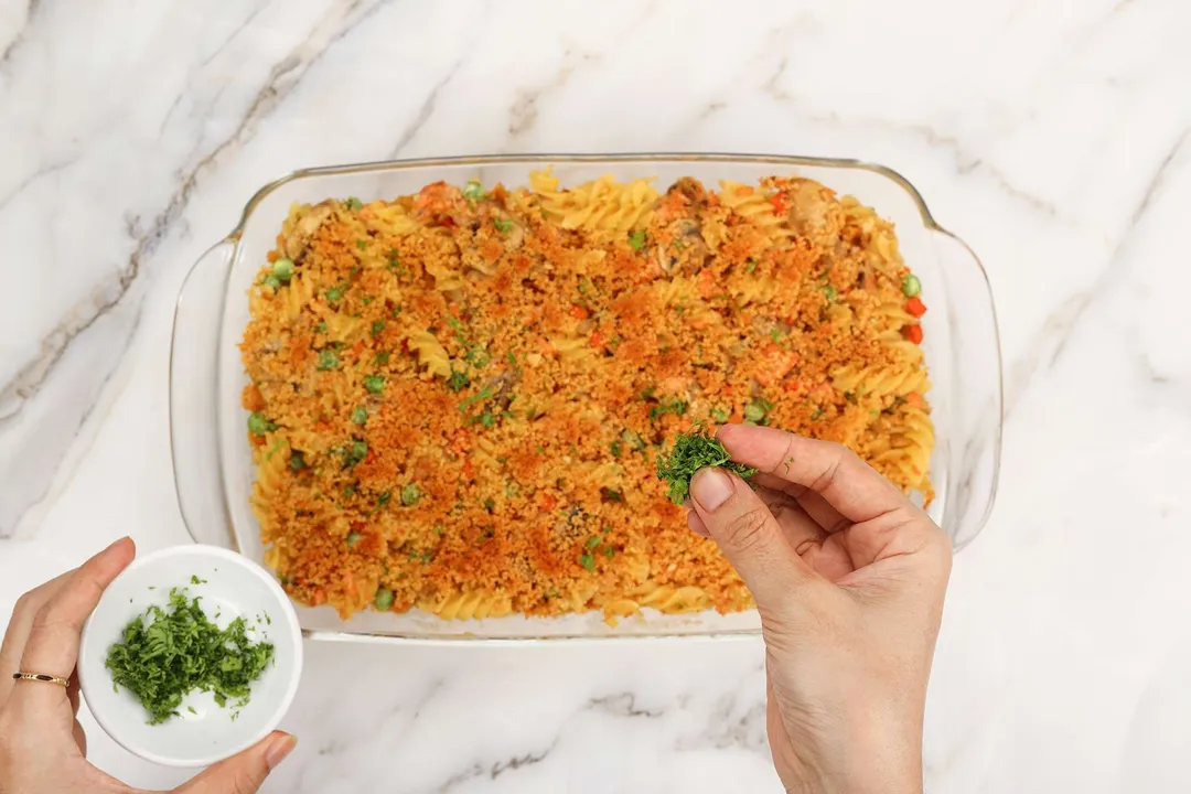 sprinkle chopped parsley on top of a cooked salmon casserole