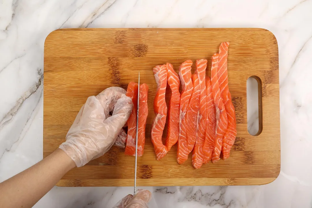 cutting salmon fillet on a cutting board