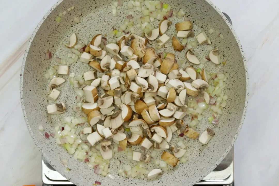 sauteeing garlic and mushroom on a skillet