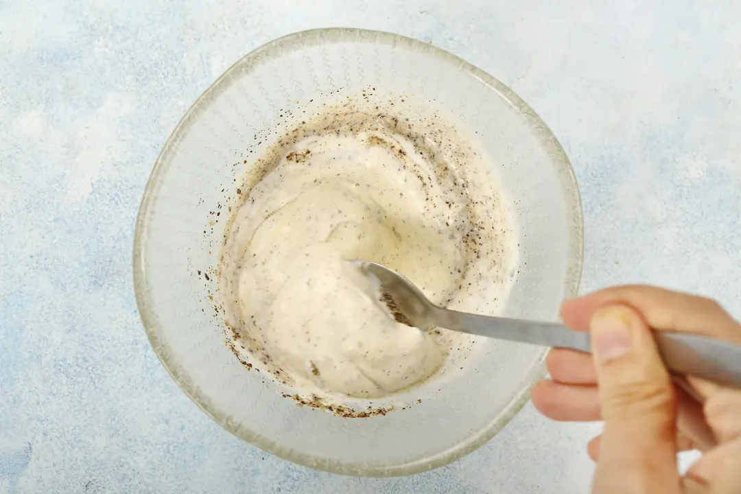 A liquid mixture is being whisked together in a small bowl.