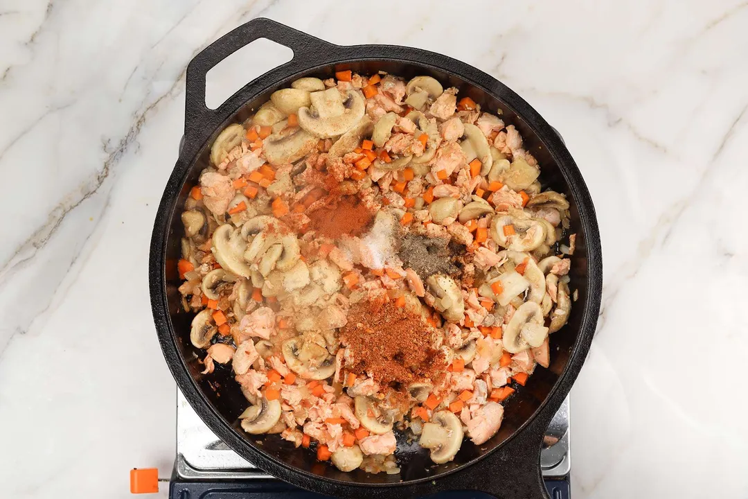 seasoning and cooked salmon, mushroom, carrot on a skillet