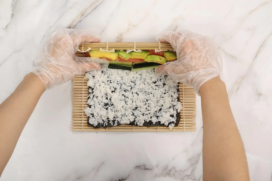 hands rolling a sushi