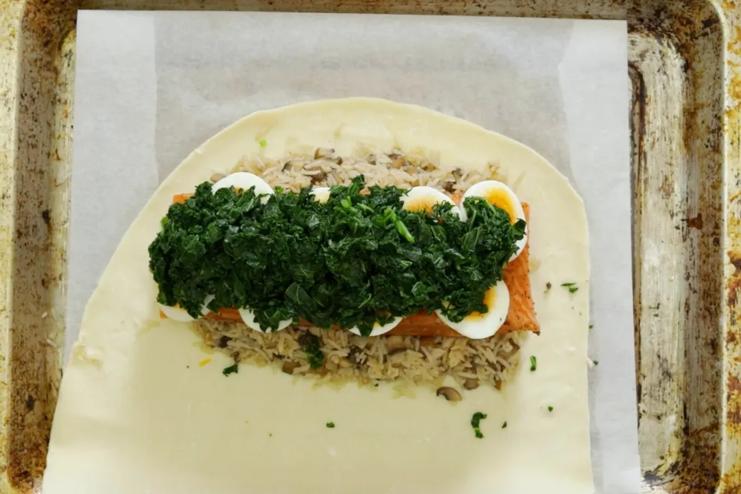 salmon fillet and chopped kale bed on pastry
