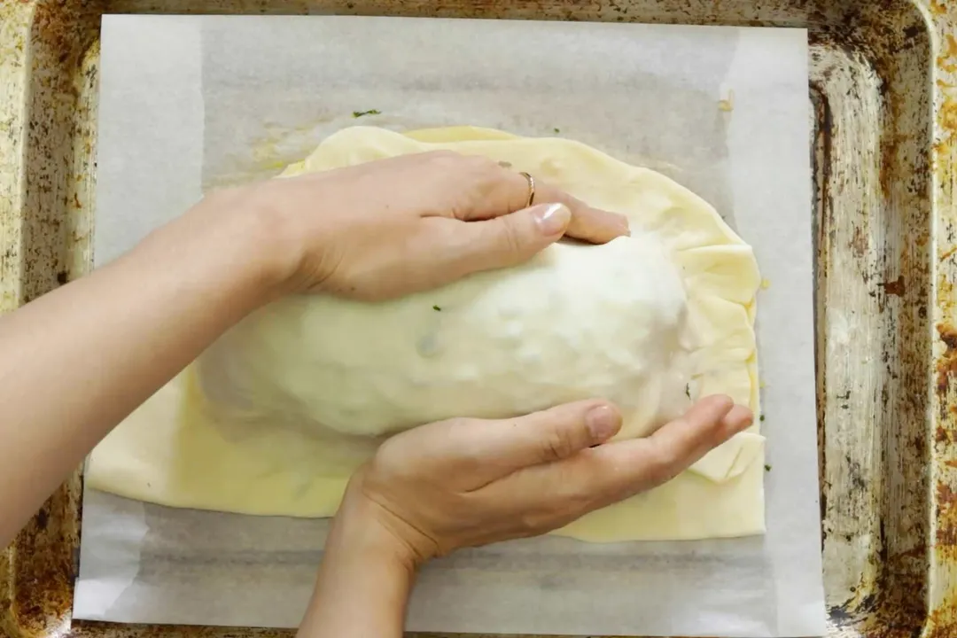 two hand wrapping pastry