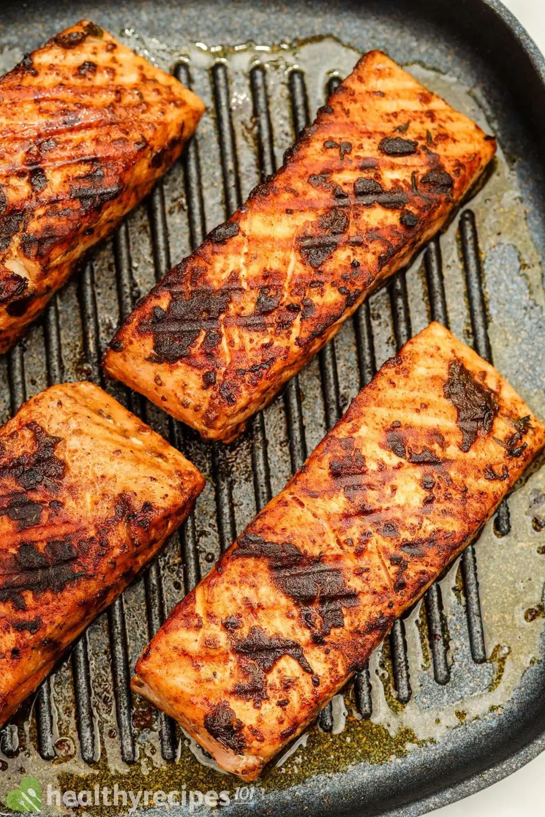 A close-up shot of seared salmon fillets in a cast iron skillet