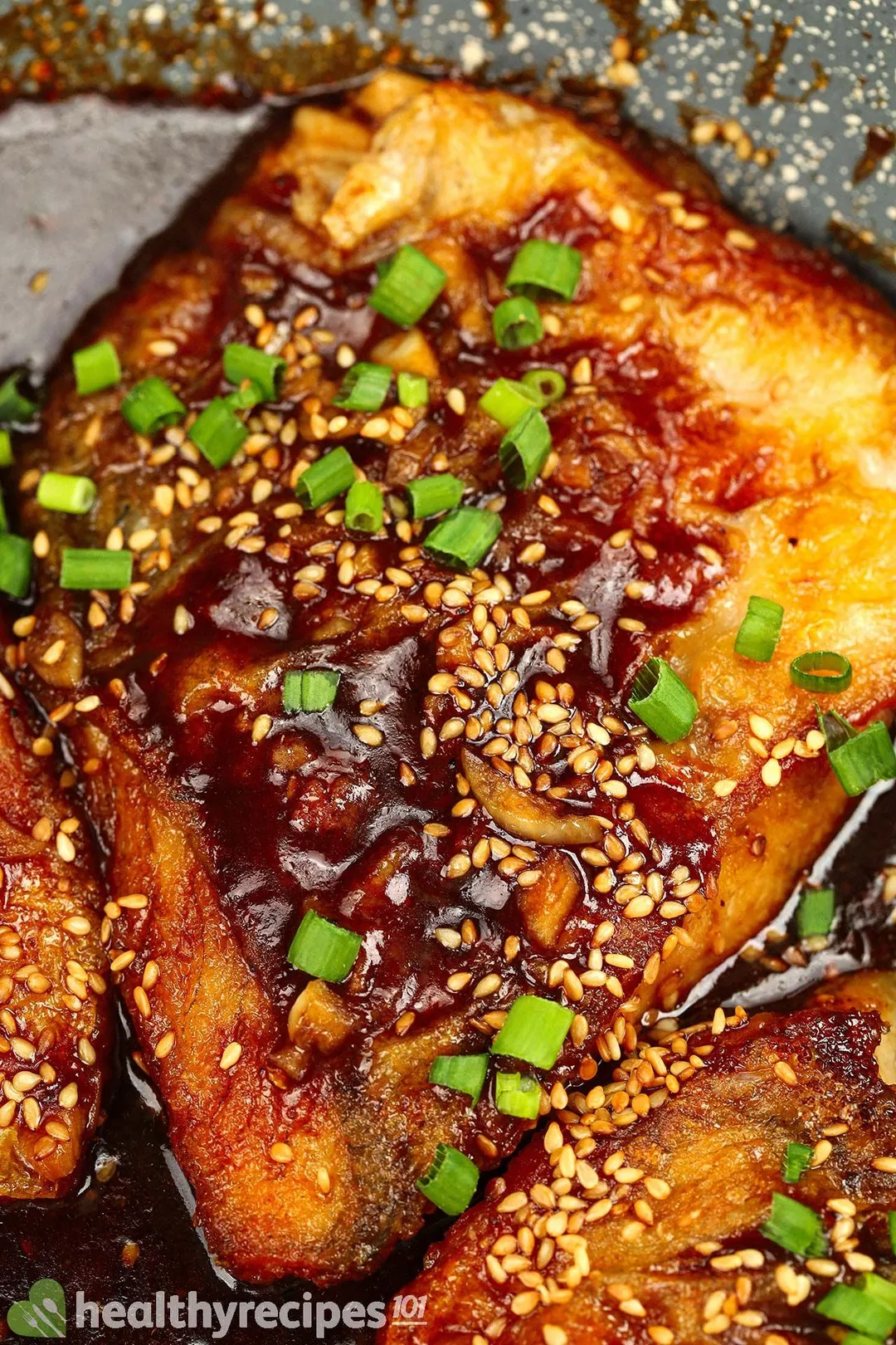 a close-up shot of sea bass fillet garnished with sesame seeds and chopped scallion