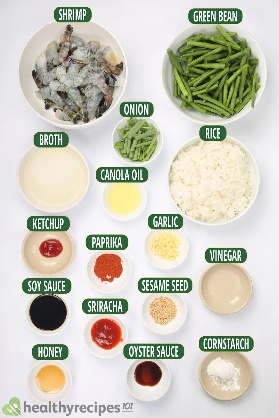 Ingredients for hunan shrimp: peeled shrimp, green beans, chicken broth, onion, cooked rice, and other seasonings, all placed in separate bowls of all sizes