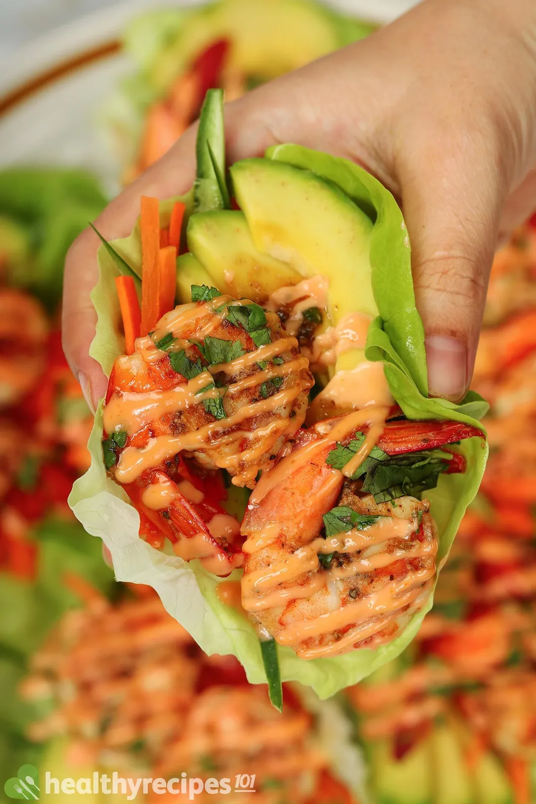 a hand holding a Shrimp Lettuce Wraps