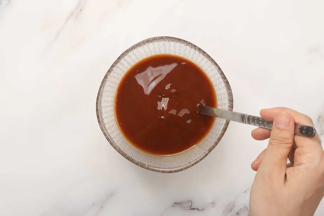 A red sauce being stirred in a small bowl