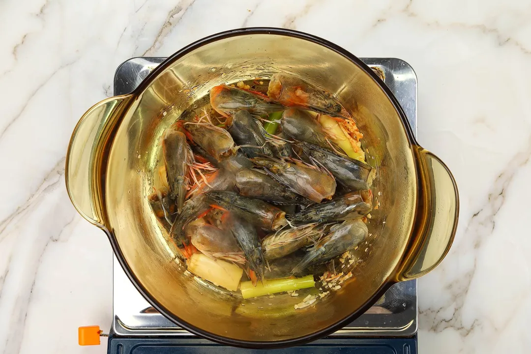 cooking shrimp heads in a pot with seasoning