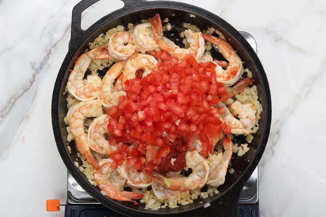 cooking shrimp and tomato in a cast iron skillet