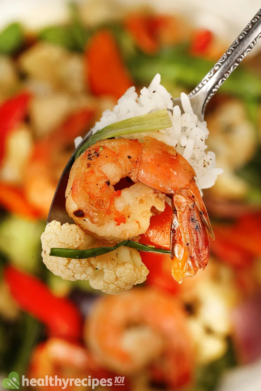 A plate of shrimp chop suey with a glass of green apple juice and a bowl of winter melon meatball soup on the background