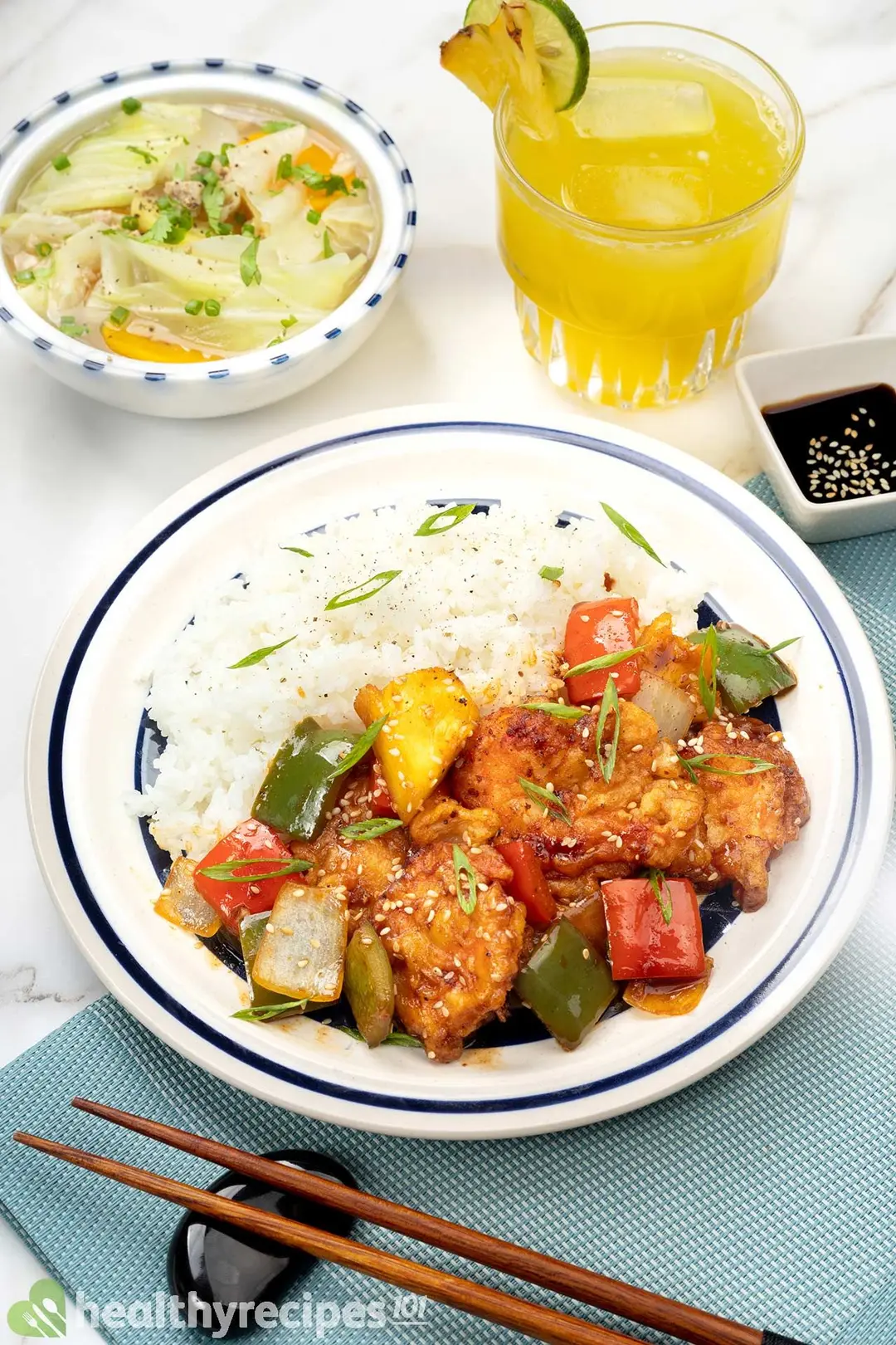 A plate of white rice, battered shrimp, peppers, and pineapples, on a blue kitchen mattress with garnishing food items