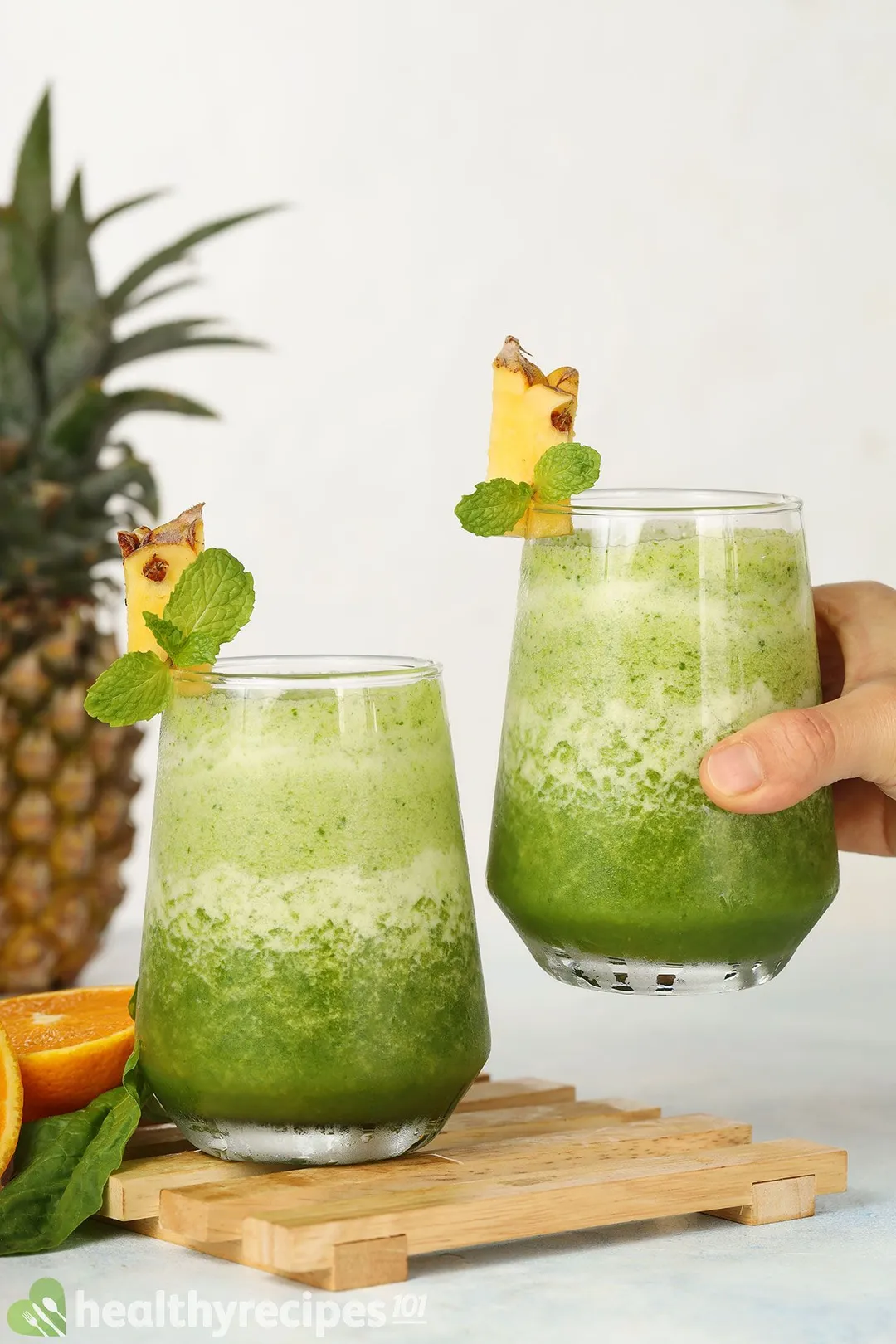 two glass of pineapple spinach smoothie, 1 on a tray