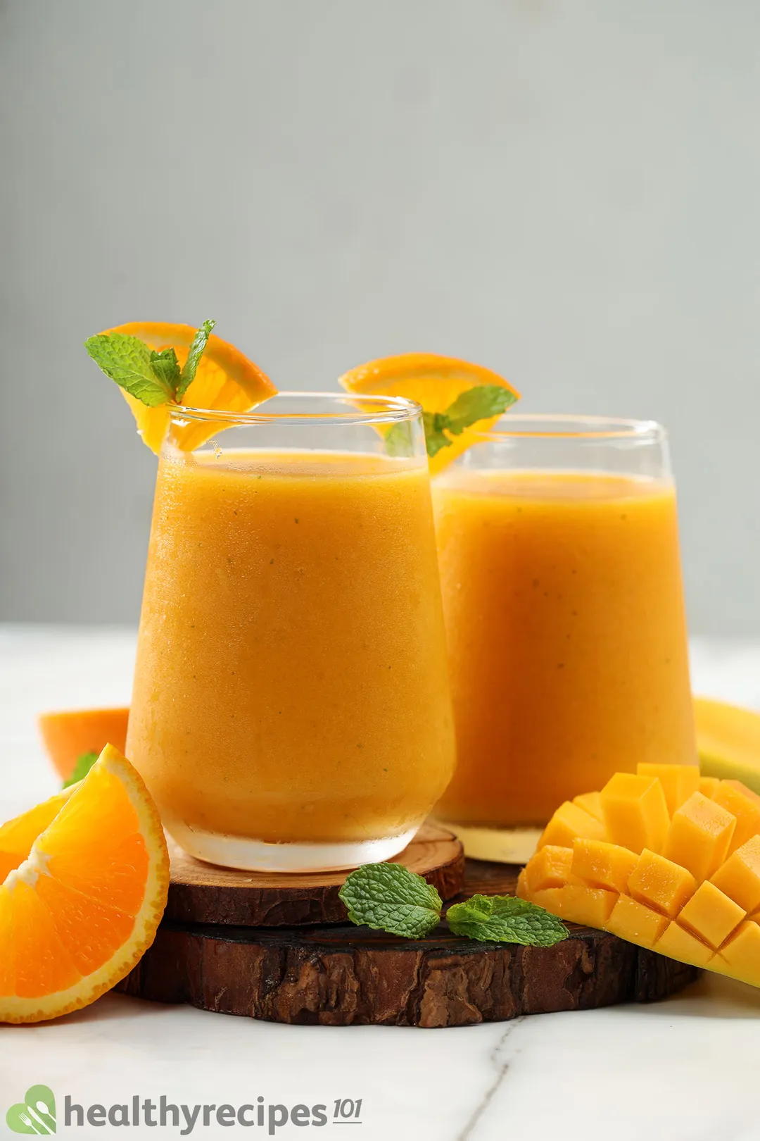two glasses of mango orange smoothie on a tray