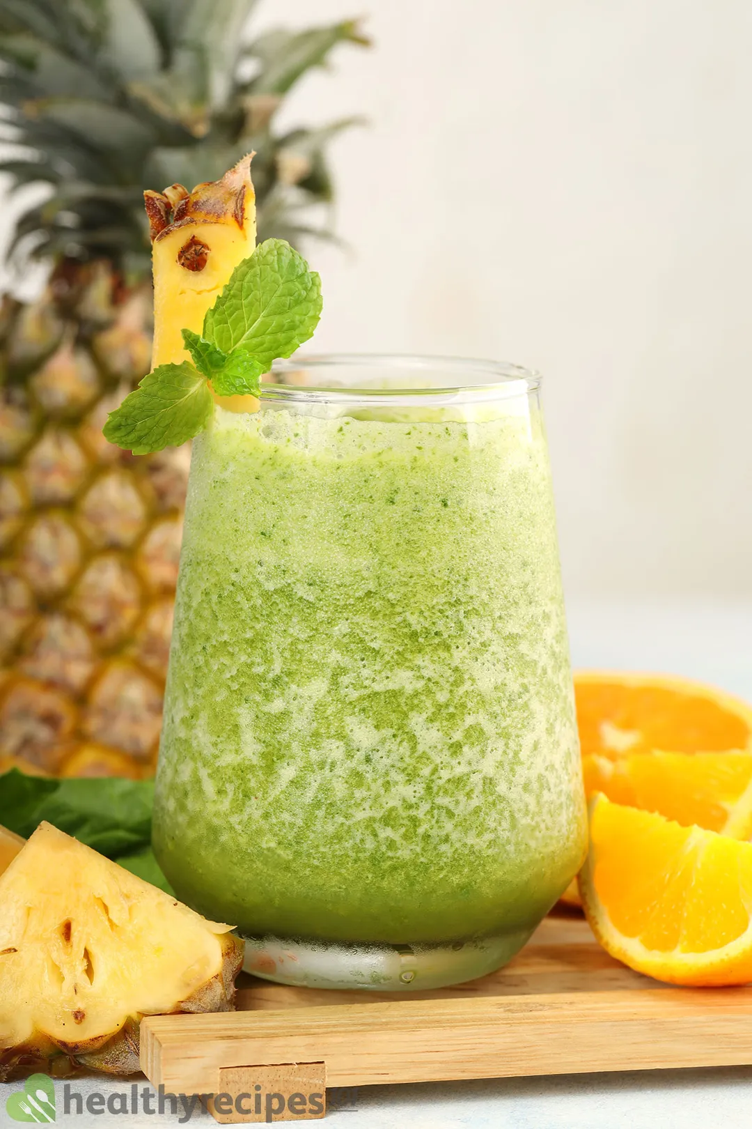 a glass of pineapple spinach smoothie on a tray