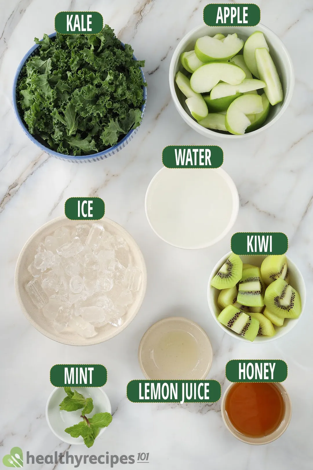 Ingredients for apple kiwi kale smoothie, including fresh kale, sliced green apples, sliced green kiwis, and other smoothie essentials.