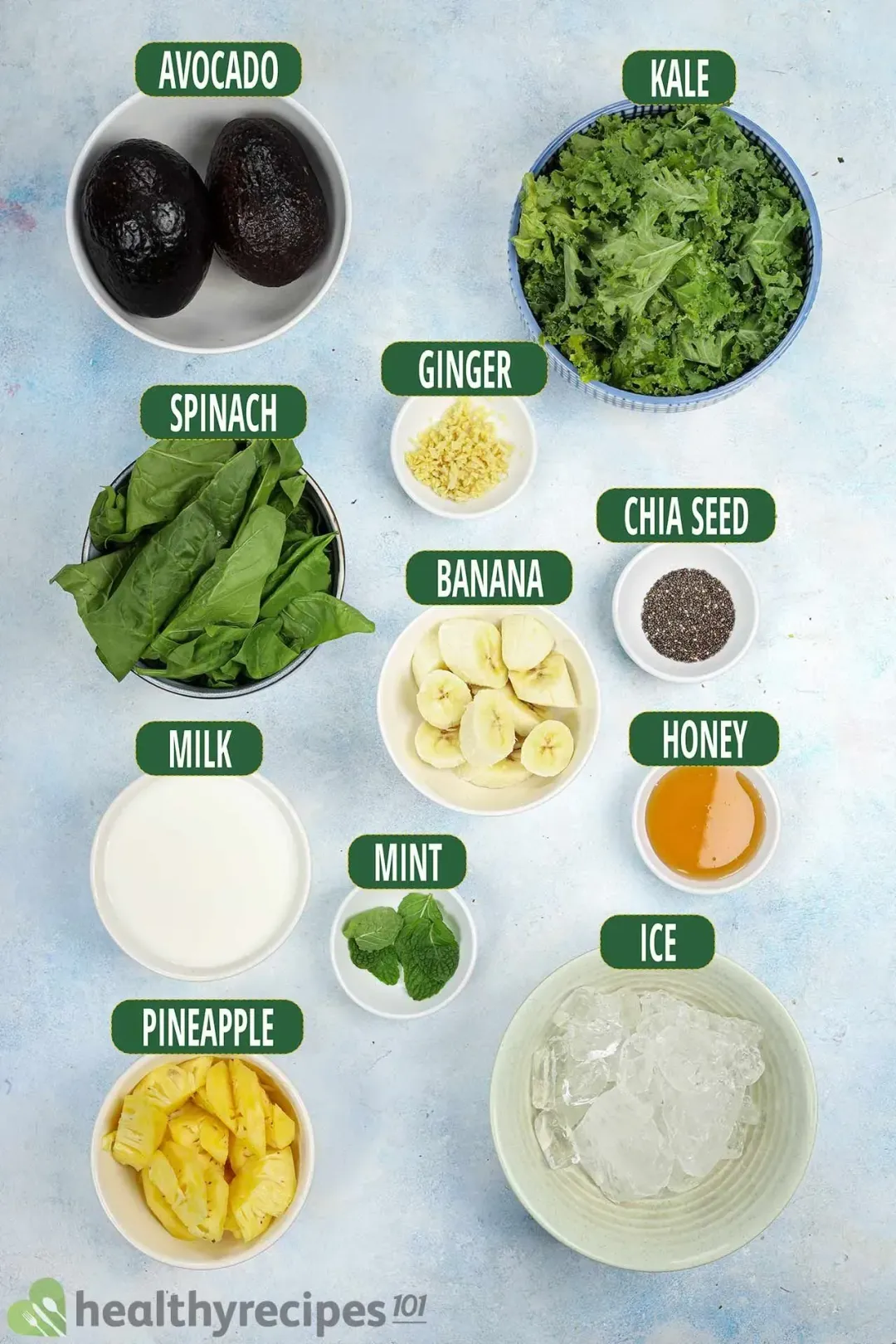 ingredients for this avocado green smoothie: avocados, kale, minced ginger, sliced bananas, pineapples, spinach, milk, ice, honey, and chia seeds